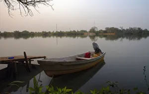 Small Fishing boat on banks of river Gambia in early morning before sunrise Small Fishing boat on banks of river Gambia in early morning before sunrise