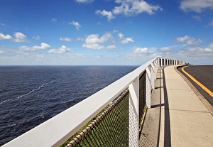 Empty walkway beside road looking down at ocean Empty walkway beside road looking down at ocean