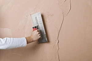 Applying a second layer of plaster to a wall using trowel Applying a second layer of plaster to a wall using trowel
