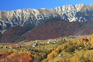 Autumn landscape of little village and mountain range in background Autumn landscape of little village and mountain range in background