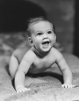 Baby (6-9 months) crawling on blanket, looking up (B&W) Baby (6-9 months) crawling on blanket, looking up (B&W)