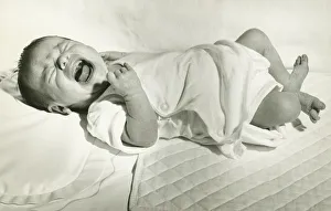 Baby boy (6-12 months) lying down on bed, crying, (B&W) Baby boy (6-12 months) lying down on bed, crying, (B&W)