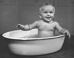 Baby boy (6-9 months) bathing in basin (B&W) Baby boy (6-9 months) bathing in basin (B&W)