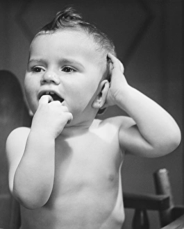 Baby boy (9-12 months) with finger in mouth (B&W) Baby boy (9-12 months) with finger in mouth (B&W)