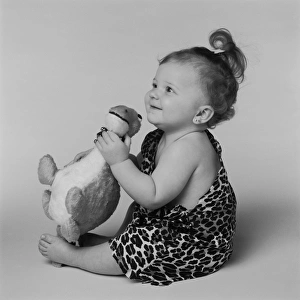 Baby girl playing with toy dinosaur, smiling Baby girl playing with toy dinosaur, smiling