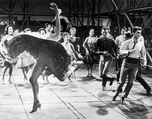 Prints of Whirling wildly and kicking up her heels, Rita Moreno, as Anita, dances with members of a Puerto Rican gang and their girlfriends support in a scene from West Side Story Rita Prints: Rita Moreno Dancing with Cast of West Side Story Print
