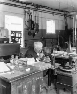 Prints of Thomas is performing an experiment in his laboratory Famous Inventors Prints: Thomas Edison Examining Microscopic Specimen Print
