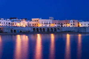 Blue hour, dusk, Seno della Purita city beach, historic centre with the church Chiesa Blue hour, dusk, Seno della Purita city beach, historic centre with the church Chiesa