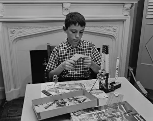 Boy (12-13) making space rocket model in living room Boy (12-13) making space rocket model in living room