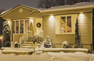 Bungalow style residential home illuminated in winter at dusk with Christmas decorations Bungalow style residential home illuminated in winter at dusk with Christmas decorations