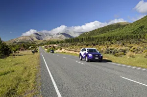 Two cars driving on a country road, driving on the left, Arthurs Pass Road, South Island Two cars driving on a country road, driving on the left, Arthurs Pass Road, South Island