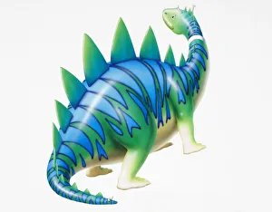 Cartoon character depiction of green dinosaur with blue stripy skin and spikes, side view Cartoon character depiction of green dinosaur with blue stripy skin and spikes, side view