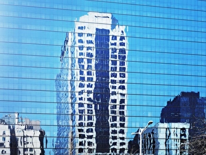 Cityscape reflected in glass facade of building Cityscape reflected in glass facade of building