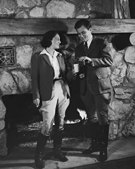 Images Dated 30th August 2005: Couple by fireplace wearing riding clothes (B&W)