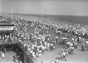 Crowd of people walking along beach, (B&W), elevated view Crowd of people walking along beach, (B&W), elevated view