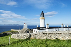 Dunnet Head lighthouse on the north coast of Scotland, Orkney Islands at back Dunnet Head lighthouse on the north coast of Scotland, Orkney Islands at back