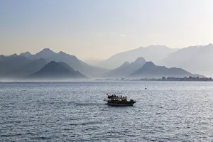 Excursion boat on the sea, in front of the Taurus Mountains, Lycian Taurus, Antalya Excursion boat on the sea, in front of the Taurus Mountains, Lycian Taurus, Antalya