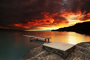 Fiery sunset over a diving board along Lake LA man Fiery sunset over a diving board along Lake LA man