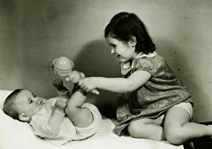 Two girls (6-12 months) (3-4) playing with rattle, (B&W) Two girls (6-12 months) (3-4) playing with rattle, (B&W)