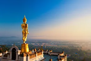 The golden standing buddha statue in Nan, Thailand The golden standing buddha statue in Nan, Thailand