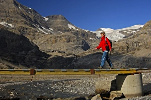 Hiker crossing a bridge over the Laemmerenbach stream, Laemmerboden plateau in front of Hiker crossing a bridge over the Laemmerenbach stream, Laemmerboden plateau in front of