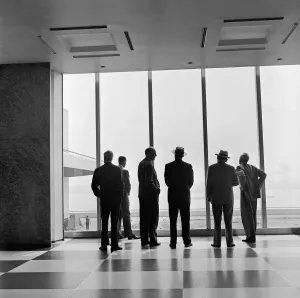 Prints of circa 1950: Visitors looking through the window in the United Nations Administrative Buildings in New York which overlooks East River and Long Island Images Dated 2021 January: UN Viewpoint Print Circa 1950: East River Scene
