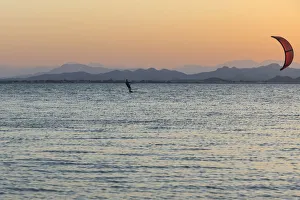 Kitesurfer, surfing on the blue lagoon of Ras Al Hadd Lagoon in the evening light Kitesurfer, surfing on the blue lagoon of Ras Al Hadd Lagoon in the evening light