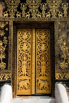 The Laotian golden gilded black lacquer art technique and wood carving at the door inside The Laotian golden gilded black lacquer art technique and wood carving at the door inside