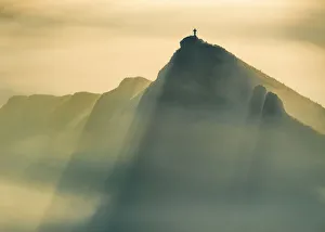 A Lone man stands on a jagged hill in misty conditions at sunrise, English Peak District. UK A Lone man stands on a jagged hill in misty conditions at sunrise, English Peak District. UK