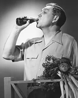 Man drinking cola from bottle in studio (B&W) Man drinking cola from bottle in studio (B&W)