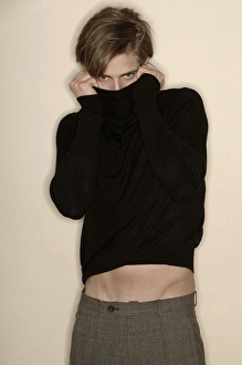 Man wearing a turtleneck jumper, collar pulled over his face Man wearing a turtleneck jumper, collar pulled over his face