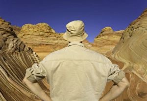 Mature man looking at sandstone buttes, rear view Mature man looking at sandstone buttes, rear view