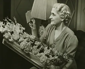Mature woman receiving box of flowers, (B&W) Mature woman receiving box of flowers, (B&W)