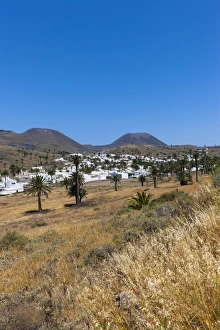 The mountain village of Haria, with its white houses, the volcano Monte Corona at The mountain village of Haria, with its white houses, the volcano Monte Corona at