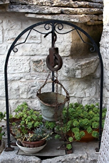 Old well and metal bucket near a Trullo house in Alberobello, near Bari, Apulia, southern Italy Old well and metal bucket near a Trullo house in Alberobello, near Bari, Apulia, southern Italy