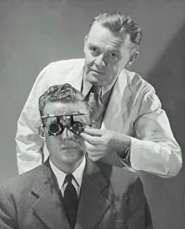 Images Dated 30th August 2005: Optometrist giving man eye examination (B&W)