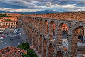 Panoramic view of Aqueduct of Segovia illuminated by the setting sun, Spain Panoramic view of Aqueduct of Segovia illuminated by the setting sun, Spain