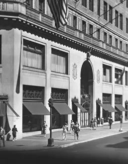 People walking on sidewalk along building (B&W) People walking on sidewalk along building (B&W)