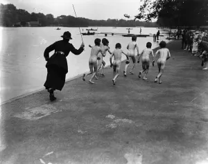 Prints of A British policewoman chasing after a group of naked street boys by the Serpentine in Hyde Park, London. (Photo by Reg Speller/Getty Images) Sight Prints: Skinny-Dippers Print: Policewoman Chases Naked Boys in Hyde Park