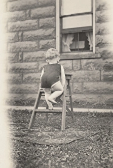 Rear View of a Toddler Climbing a Stepladder in a Garden Rear View of a Toddler Climbing a Stepladder in a Garden