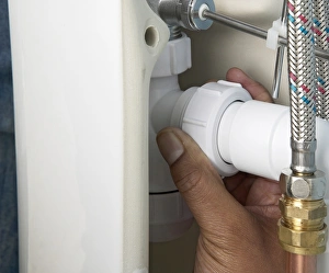 Screwing a trap connector nut onto a waste pipe Screwing a trap connector nut onto a waste pipe