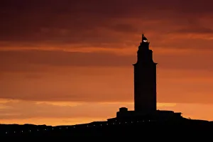 Silhouette of Hercules Tower at orange sunset Silhouette of Hercules Tower at orange sunset