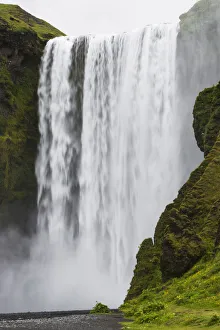 Skogafoss waterfall in heavy mist from long fall, Southwest Iceland, Iceland Skogafoss waterfall in heavy mist from long fall, Southwest Iceland, Iceland