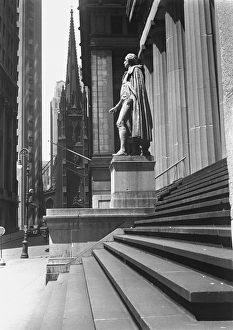 Statue at steps in front of building, Wall Street, Trinity Church in distance Statue at steps in front of building, Wall Street, Trinity Church in distance