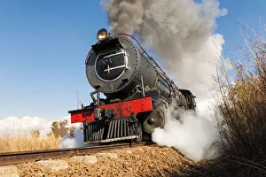 Steam locomotive puffing at full speed on railroad track, Magaliesburg, Gauteng Province Steam locomotive puffing at full speed on railroad track, Magaliesburg, Gauteng Province