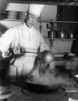 Steaming Wok Print circa 1940: A Chinese chef in London kitchen