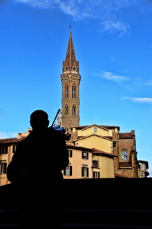 Street musician plays a violin in front of Badia Fiorentina bell-tower in Florence, Italy Street musician plays a violin in front of Badia Fiorentina bell-tower in Florence, Italy