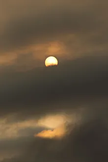Sun behind clouds and brownish ash and gas clouds of the Holuhraun fissure eruption Sun behind clouds and brownish ash and gas clouds of the Holuhraun fissure eruption