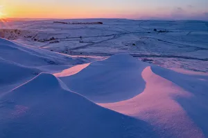 Sunrise over snow drifts in the English Peak District. UK Sunrise over snow drifts in the English Peak District. UK