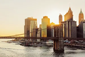 Sunset over Brooklyn Bridge and skyline of Manhattan Financial District in Downtown, New York City, NY, United States Sunset over Brooklyn Bridge and skyline of Manhattan Financial District in Downtown, New York City, NY, United States